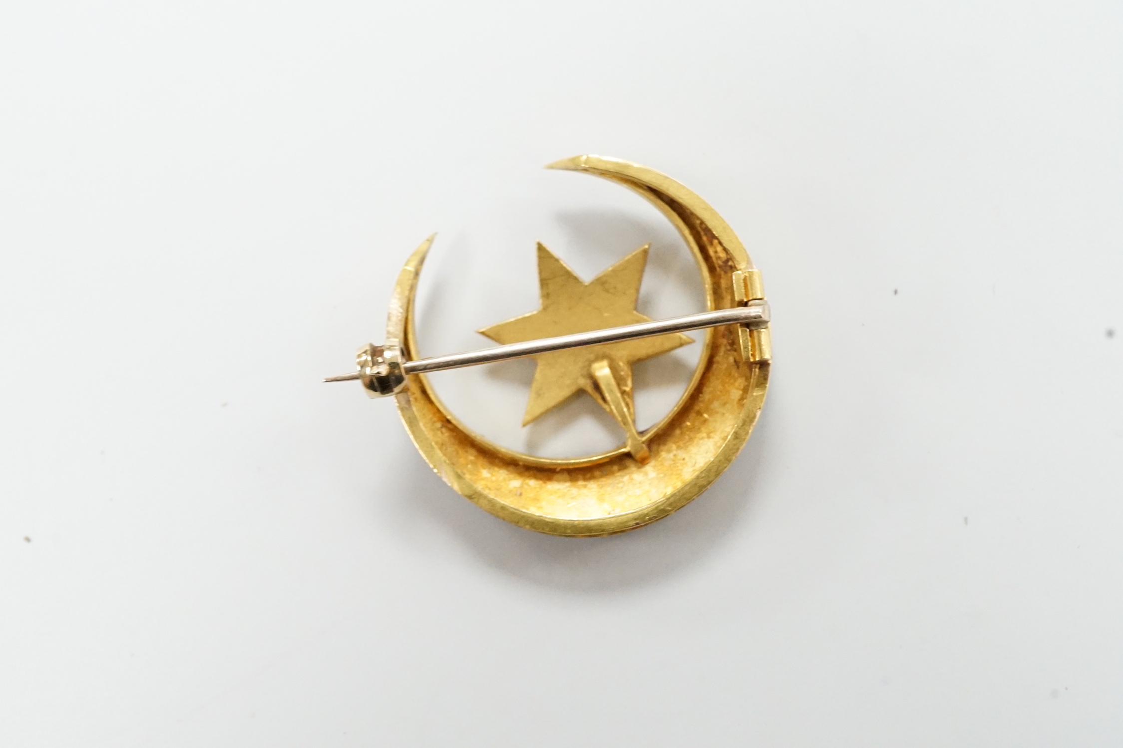 An Edwardian yellow metal and seed pearl set 'star and crescent moon' brooch, 26mm, 6.1 grams, in fitted case.